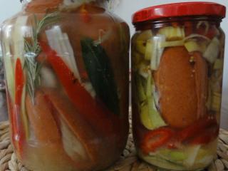 Jak si naložit hermelín a špekáčky | recept Špekáčky podélně nakrájíme a do zářezů nasypeme mletou papriku, pepř a vložíme proužek cibule. Místo mleté papriky můžeme použít nakrájený paprikový lusk. Povrch špekáčků potřeme hořčicí a do sklenice klademe střídavě vrstvu cibule pokrájené na kolečka a vrstvu uzeniny. Cibulí nešetříme. Zdobíme paprikou, pórkem a bobkovým listem. Poslední vrstva v láhvi by měla být cibulová. Zalijeme vlažným nálevem a necháme v chladu a temnu rozležet 10 dní.